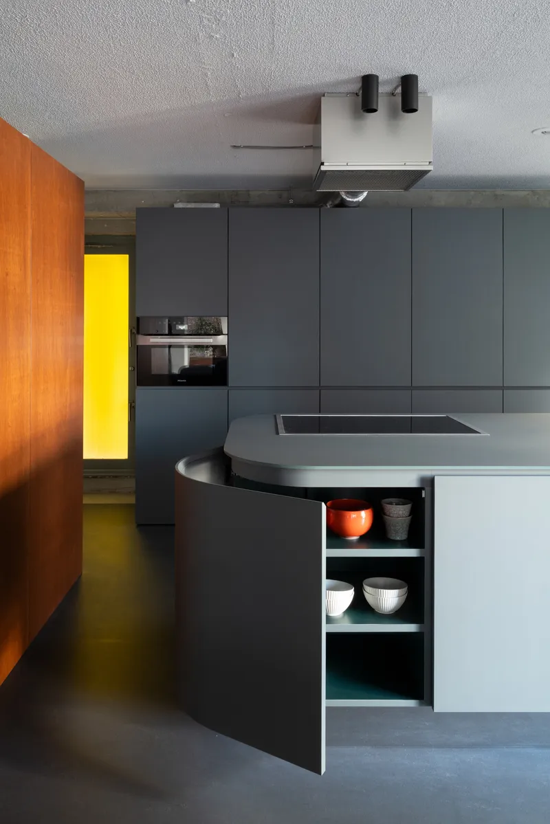 Kitchen island with curved open storage cabinet revealing bowls and dishware on white shelves