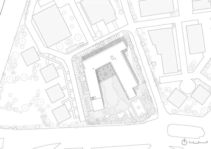 Site plan drawing showing residential building footprint with central courtyard surrounded by street trees