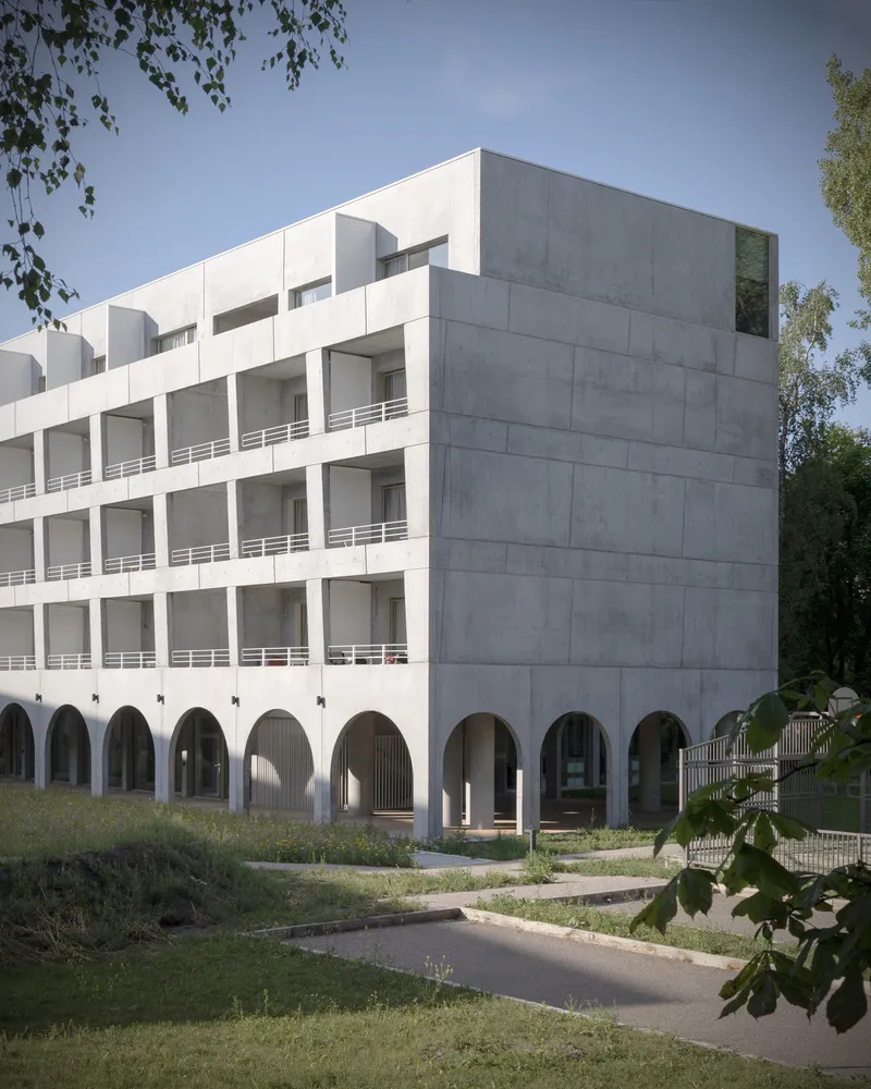 Corner view showing the white and grey concrete facade with arched ground floor and recessed balconies
