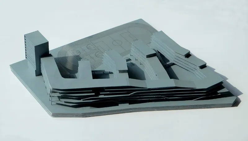 Physical model in grey and black showing layered volumes above a striated base platform