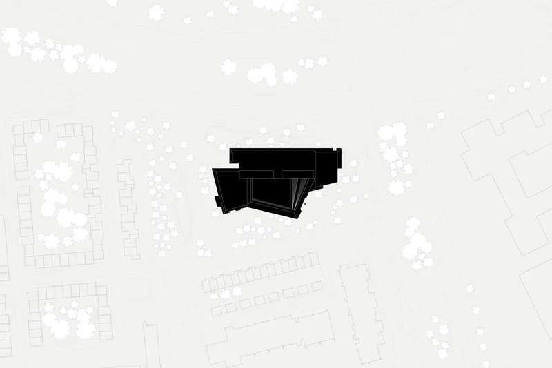 Site plan drawing showing the angular building footprint surrounded by trees and neighboring structures