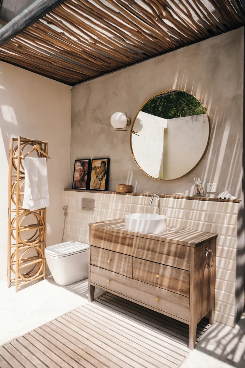 Bathroom with striped timber slat ceiling casting shadow patterns across plaster walls and tiled floor
