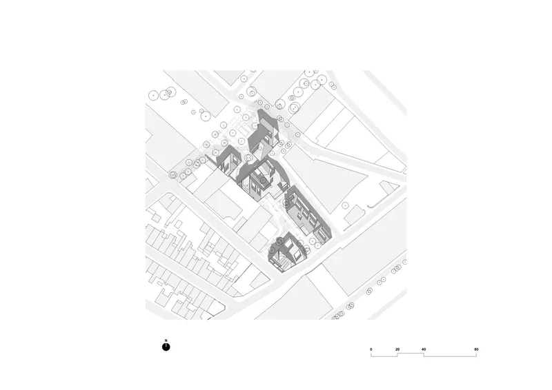 Axonometric site plan drawing showing clustered building volumes and surrounding street grid with trees