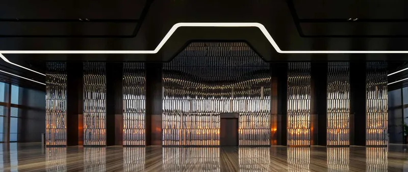 Empty lobby hall with patterned metal screen walls and angular light fixture tracing the ceiling plane