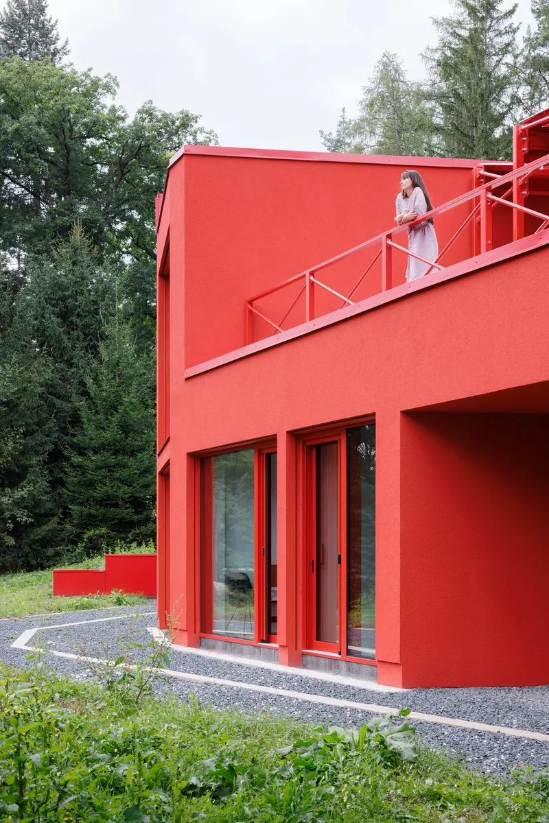Person ascending the diagonal exterior staircase with metal railing under an overcast sky