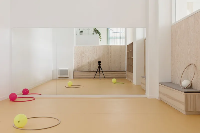 Activity room with amber rubber flooring, mirrored wall, and brightly colored balls arranged in floor circles