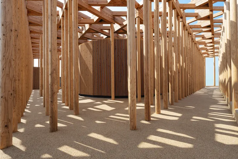 Timber colonnade with slatted wooden doors at center and strong shadows cast across the gravel floor
