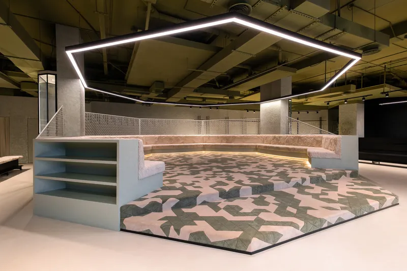 Angled view of the stepped seating pit with integrated shelving units and exposed concrete columns above