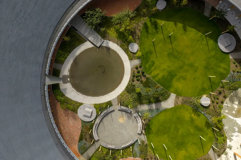 Overhead view of the central courtyard with circular water feature and lawn panels between planted beds