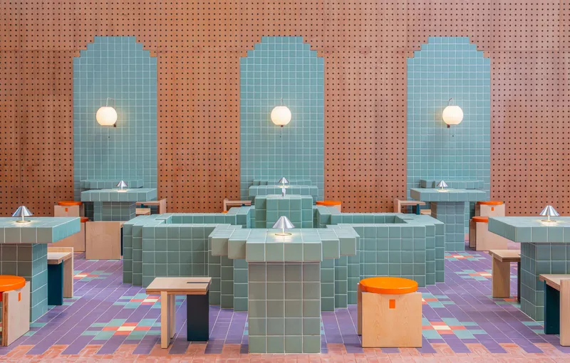 Interior dining area with arched blue tile alcoves, perforated terracotta walls and multicolored floor tiles