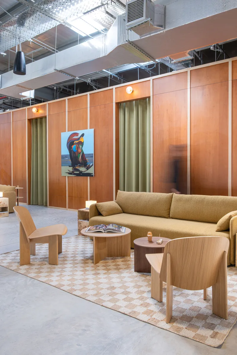 Timber paneled wall with olive curtains and warm pendant lighting in a lounge area