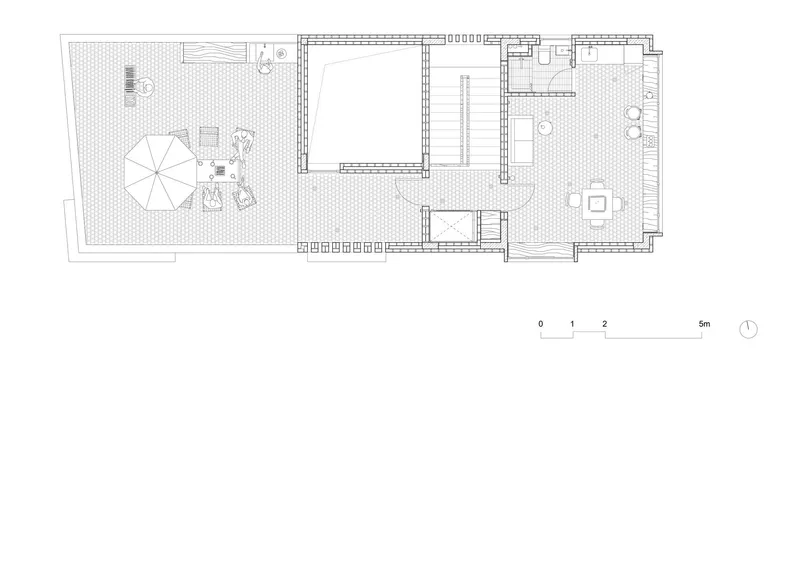 Floor plan drawing showing a narrow residential layout with a courtyard and central circulation spine