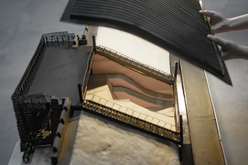 Sectional model revealing terraced interior levels and curved balconies within the main hall
