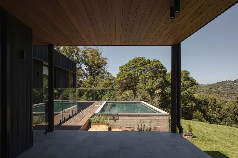 Timber soffit framing a view of the elevated pool deck and hillside beyond