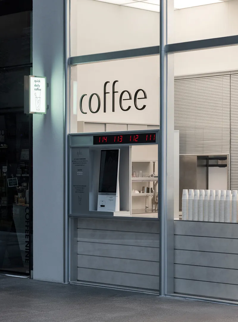 Service window with horizontal slats, digital clock display, and gray steel frame columns