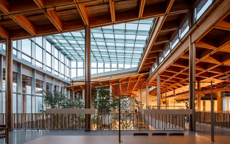 Interior atrium with timber coffered ceiling, central skylight and planted courtyard surrounded by balconies