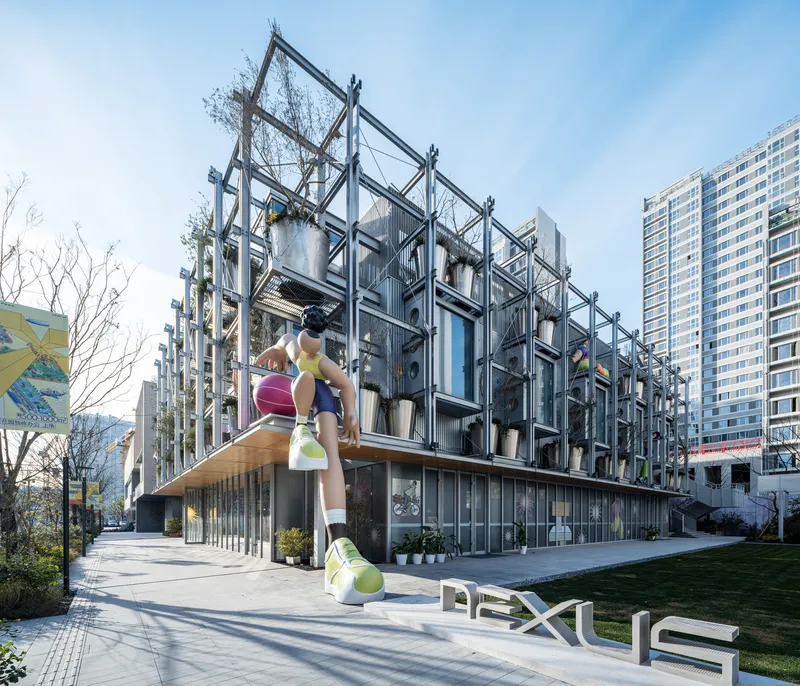 Steel exoskeleton facade with climbing figure sculpture and planted modules above a glazed ground floor