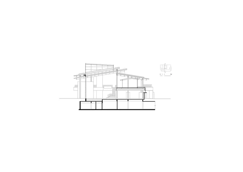 Section drawing revealing the sloped roof structure above multi-level interior spaces with a basement below