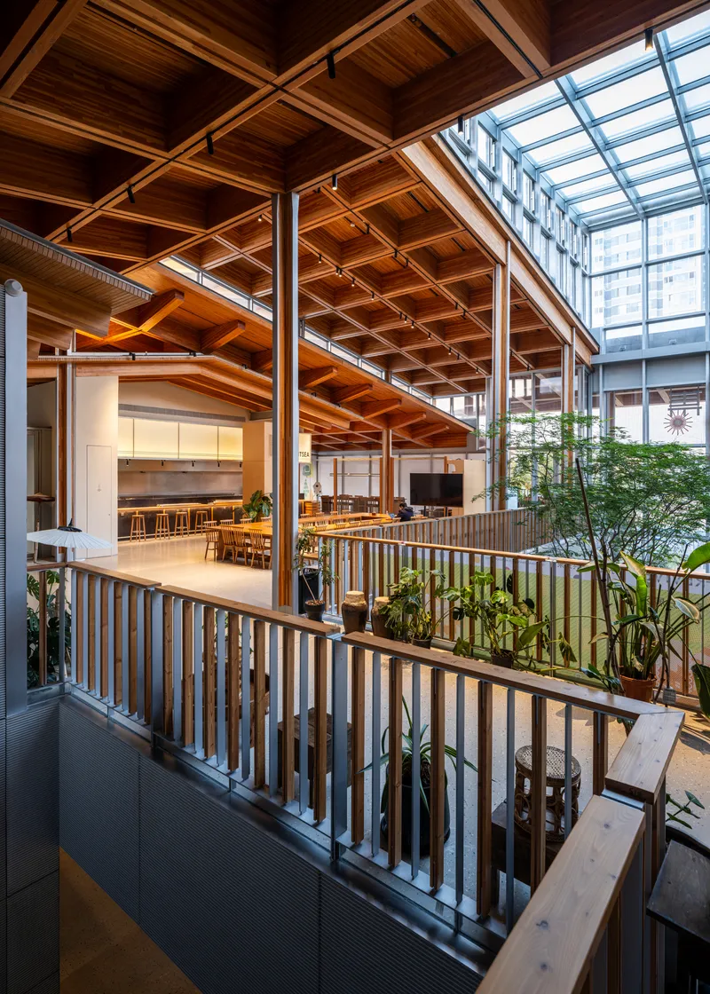 Interior balcony view with vertical timber railings, exposed wood beam ceiling and steel columns