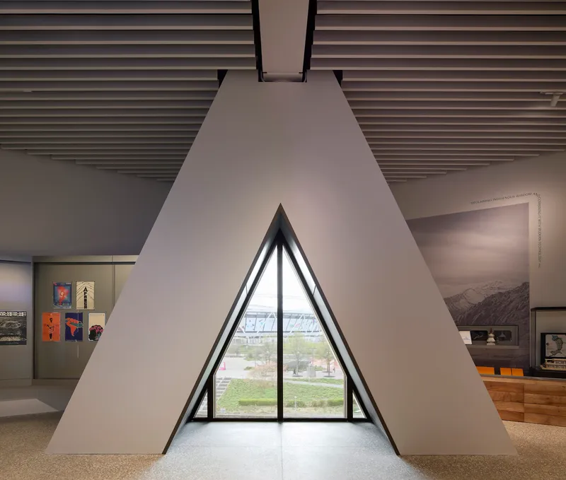 Triangular window alcove framing a view of the landscape with gallery displays on adjacent walls