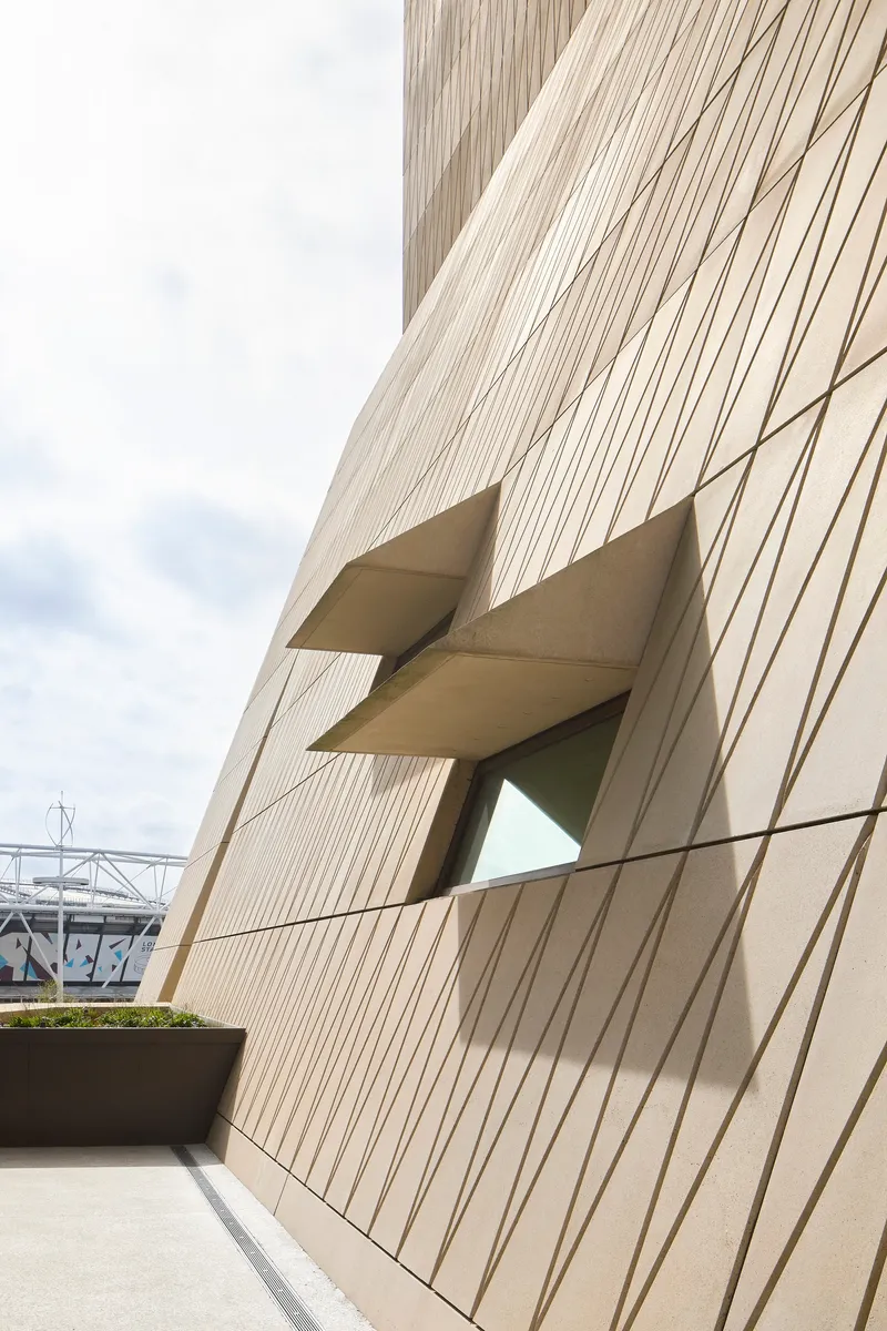 Detail of the angular window recess cutting through the vertically ribbed facade panels