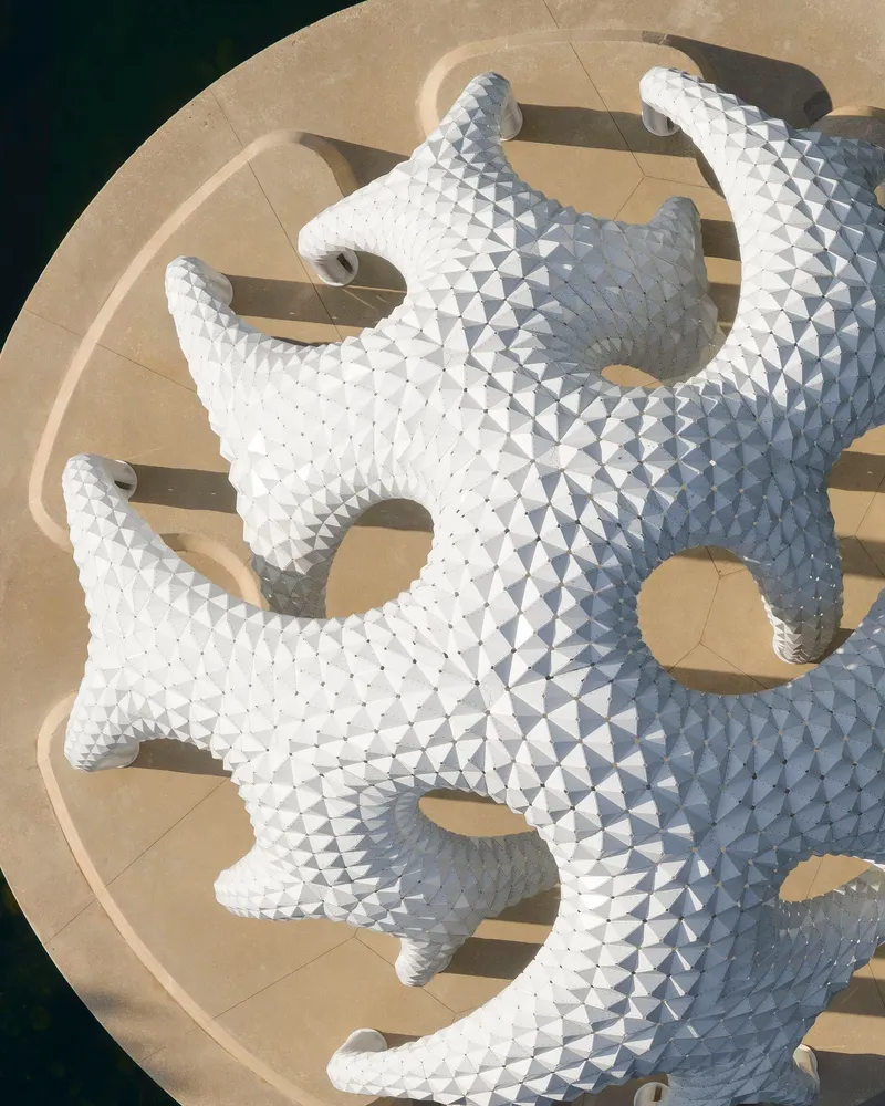 Aerial view of the white tile-clad pavilion roof with lobed openings on a circular platform