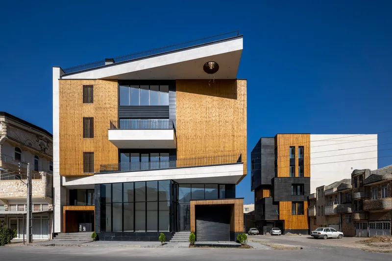Street view of the timber and white panel facade with projecting canopy under a clear blue sky