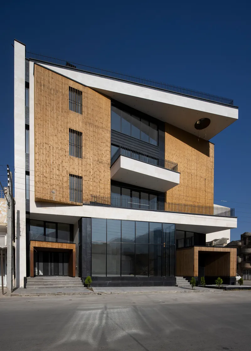 Front elevation featuring vertically layered timber panels and recessed balconies with metal railings