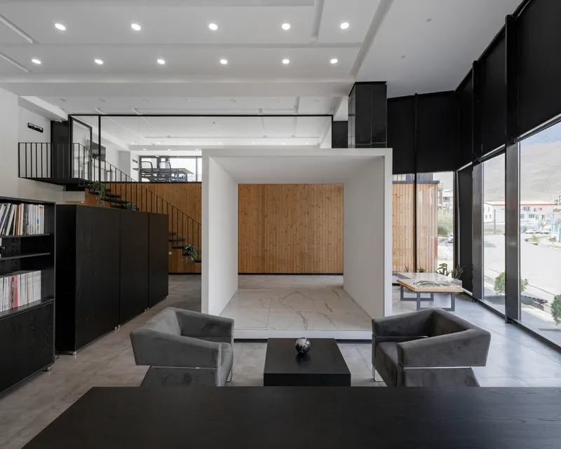 Double-height lobby with coffered white ceiling, black walls, and timber accent wall visible beyond