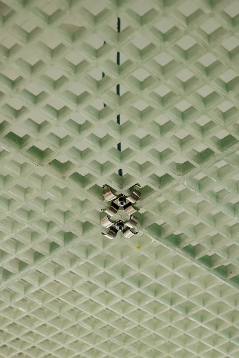 Overhead view of green chevron-patterned textile ceiling with chrome pendant lamp fittings