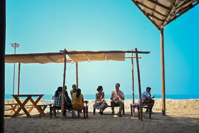 Open-air shaded seating area with canvas awning overlooking the beach and ocean