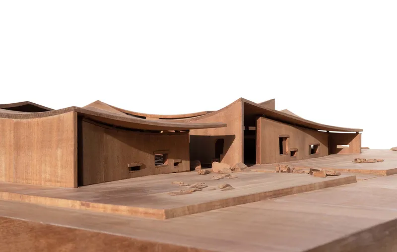 Physical model of undulating roof forms with window openings and scattered site elements