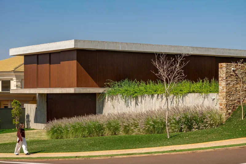Upper-level timber facade with planted green roof terrace and pedestrian on the sidewalk below
