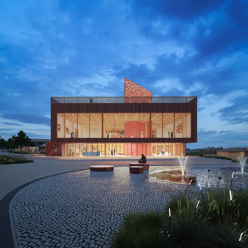 Illuminated glass facade with perforated red metal screen and triangular rooftop element at dusk