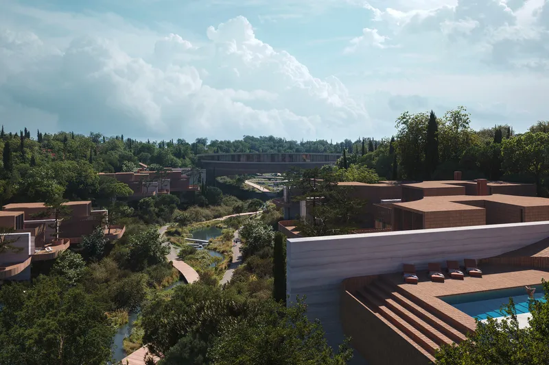 Aerial view of terracotta-roofed structures scattered across a vegetated landscape with a pond below