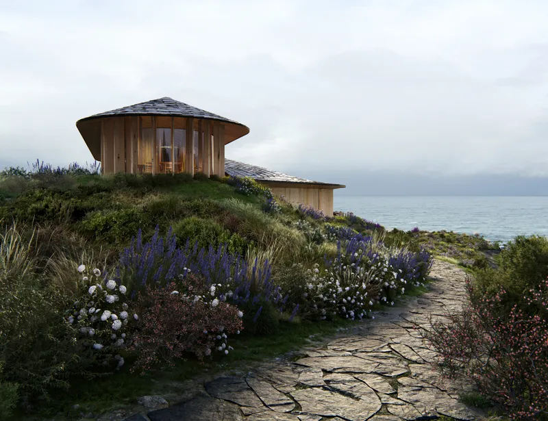 Cylindrical timber pavilion with glazed walls on a coastal hillside planted with lavender and roses
