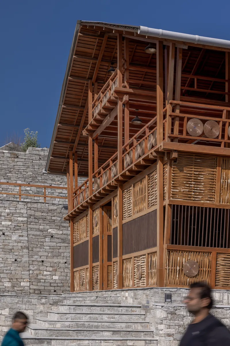 Corner view of the diagonal timber staircase connecting the upper balcony with pedestrians on the stone steps