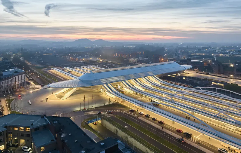 Aerial view of the illuminated terminal building with its ribbed roof at dusk