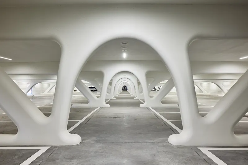 Underground pedestrian passage with repeating white arched structural frames creating rhythmic perspective