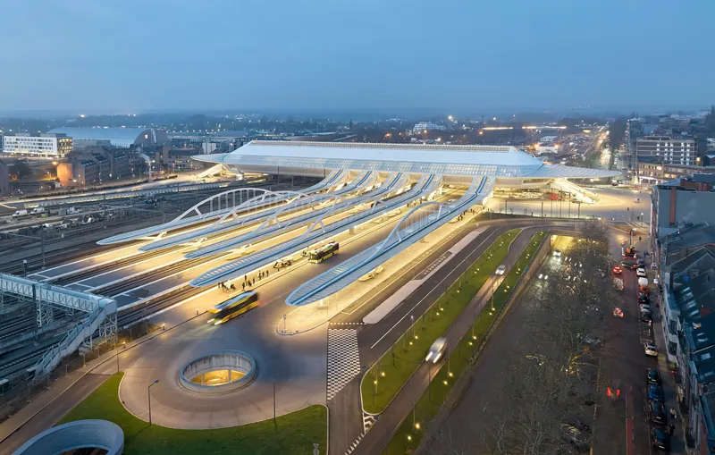 Aerial view of illuminated station canopy and forecourt plaza at dusk