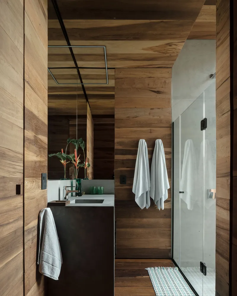 Bathroom with horizontal timber plank walls, floating vanity, glass shower enclosure and white towels