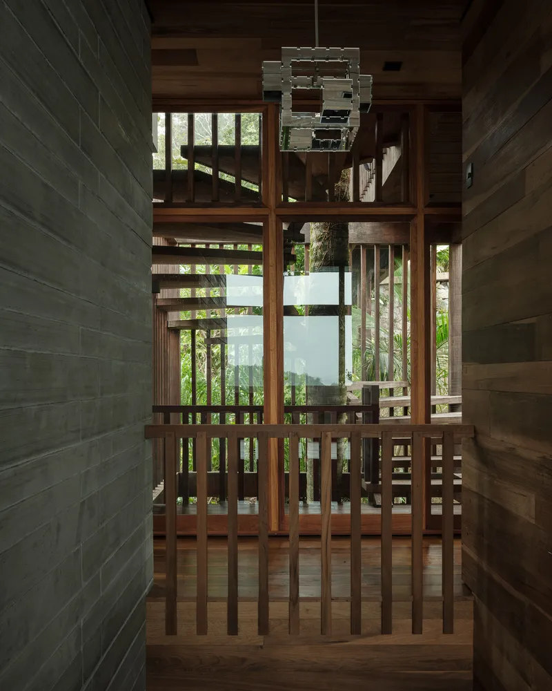 Timber screen partition with vertical slats and glazed doors overlooking an interior courtyard