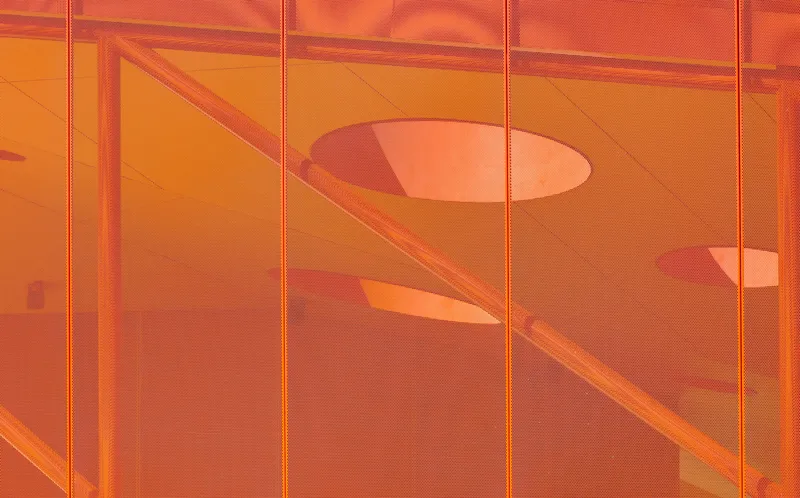 Translucent orange panel showing shadows of interior handrails and circular ceiling openings