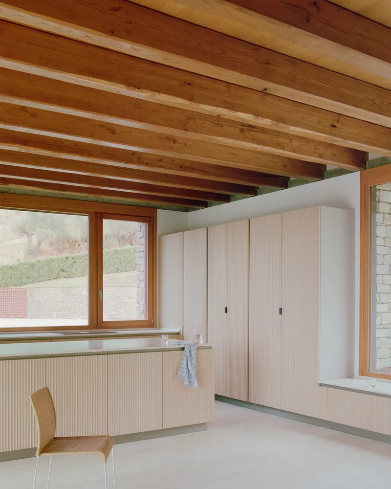 Interior room with exposed timber ceiling beams and pale wood built-in cabinetry along the walls