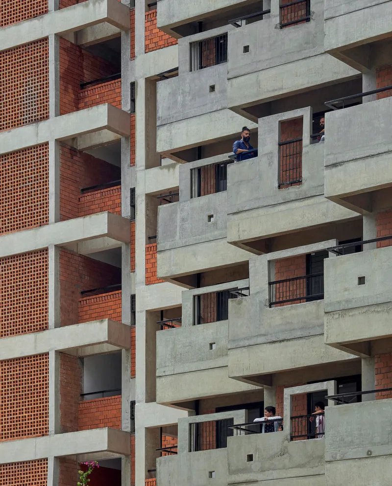 Offset concrete balconies with residents occupying the outdoor spaces at different levels