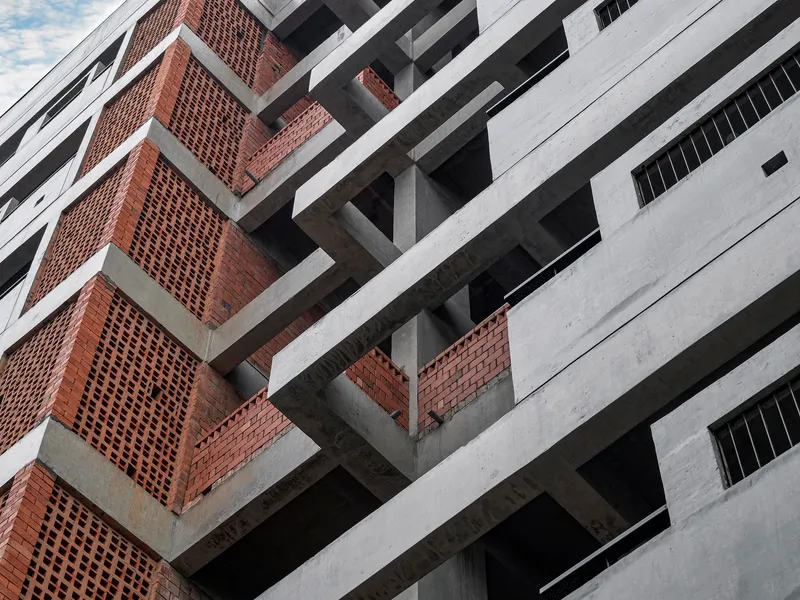 Angled view of the intersecting concrete slab edges and perforated brick screen panels