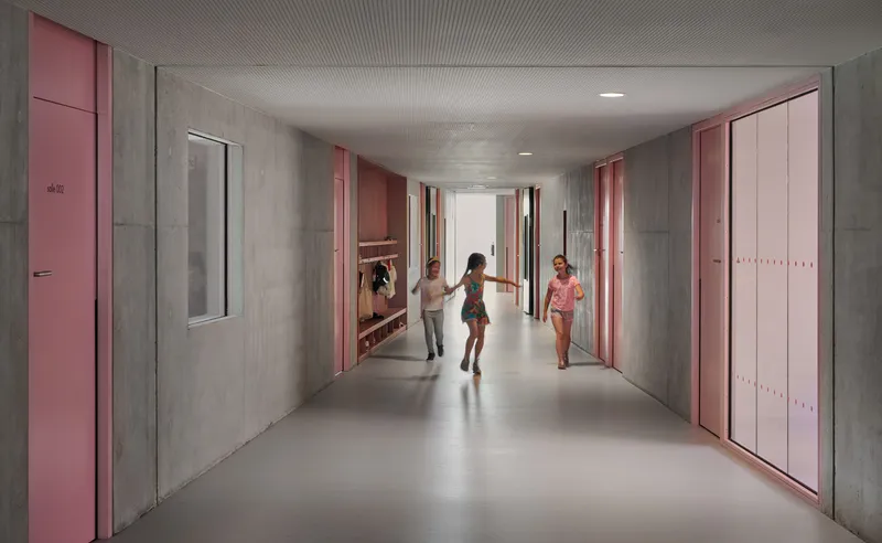 Corridor with pink doors and concrete walls where children run through the space