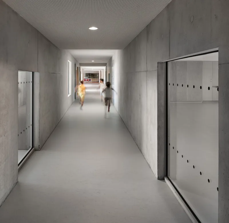 Concrete hallway lined with white locker units as two blurred figures run past