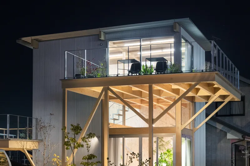 Close-up of the exposed timber truss supporting the upper deck and roof overhang at night