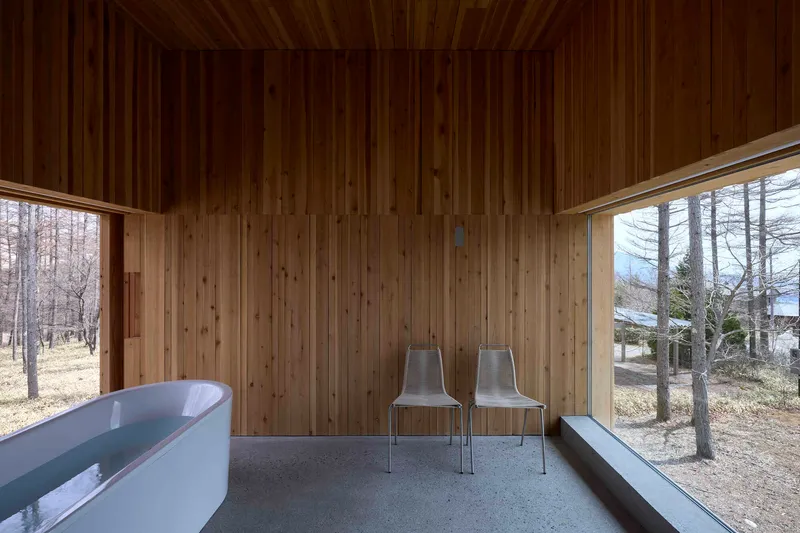 Interior room with vertical timber walls and ceiling, polished concrete floor, and two corner windows